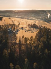 Wide landscape with fields and forests under bright sunlight from the air, Althengstett sports