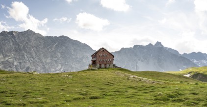 Mountain hut Neue Reichenberger Hütte in front of the rocky mountain peaks of the Panargenkamm,