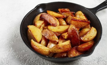 Fried potato slices, in a cast-iron pan, homemade, no people