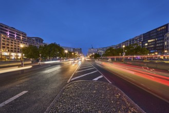 Leipziger Straße with lanterns, buildings and vehicles with traces of light at the blue hour, dusk