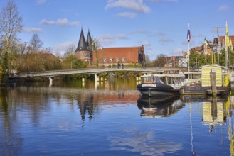 River Trave, pedestrian bridge Obertravebrücke, Holstentor, blue sky with fair weather clouds,