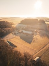 View of a farm and wide fields in the golden light of the early morning, Gechingen district of