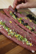 Swabian cuisine, preparation of lamb with prunes, raw lamb stuffed with herbs, rosemary, sliced