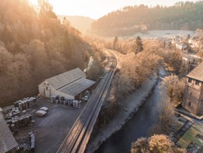 Sunset over a railway line and river, bordering a village and wooded hills, Kentheim, district of