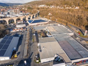 Aerial view of an industrial landscape next to a viaduct, surrounded by wooded hills, Nagold, Black