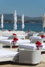 White deckchairs with red towels on the coast overlooking the sea, Amadria Park, En Vogue Beach