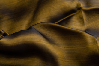 Fragment of yellow and green tissue. Side view, synthetic textile background and texture. wave