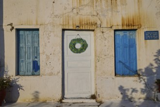 Detail of a house with blue shutters and decorated white door, Pyles village, west coast,