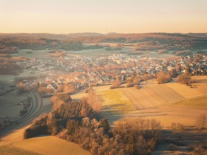 Rural village with surrounding fields at sunrise in autumnal atmosphere, Gechingen district Calw,