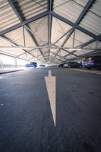 Car park with a painted arrow on the floor and parked cars, Kaufland Calw car park, Calw district,