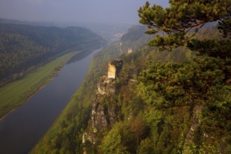 The bright lit Wartturm above the Elbe river seen from the Bastei rocks near the village of Rathen