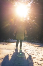 Person on snow-covered road, sunbeams and long shadows, Seewald, Black Forest, Germany, Europe