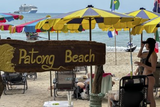 Patong beach on the Indian Ocean with parasol and cruise ship. Patong, Kathu, Phuket Island,