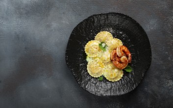 Ravioli with shrimp, in cream sauce, with spices and herbs, top view, no people