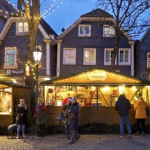 Nostalgic Christmas market on the church square in front of half-timbered houses in the evening,