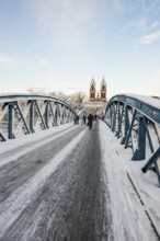 Bridge with snow and ice and cyclists, Blue Bridge and Stühlinger Church, Freiburg im Breisgau,