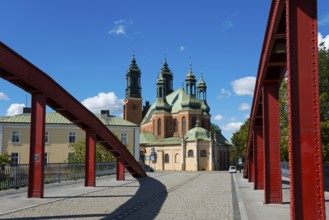 The bridge with red arches leads directly to a historic church with dominating towers, Cathedral,