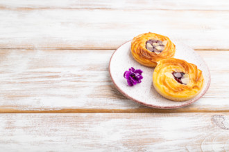 Small cheesecakes with jam and almonds on a white wooden background. Side view, copy space