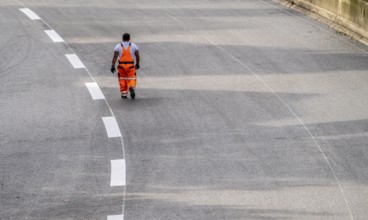 Marking work after the application of new whisper asphalt surface for the A40 motorway, in the