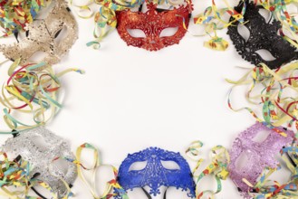 Colourful masks and paper snakes on a white background, carnival atmosphere