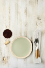 A minimalistic dining arrangement showcases a pale green plate next to a cup of dark beverage,