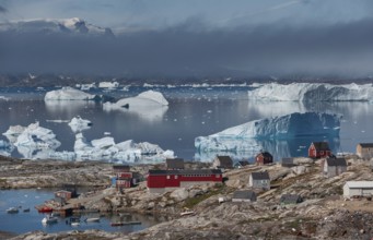 Large icebergs floating in fjord behind Inuit settlement Tiniteqilaaq, Sermilik Fjord, East