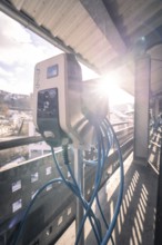 Charging station for electric vehicles with outgoing cables in sunlight, Kaufland Calw multi-storey