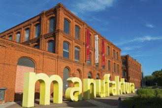 Historic building with yellow signage, blue sky. Popular cultural centre in an urban setting,