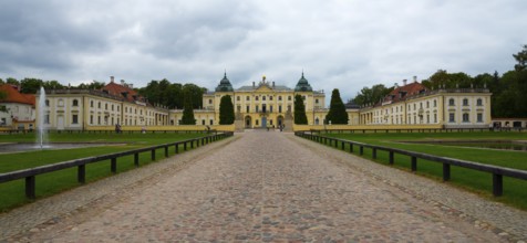 Front view of a baroque palace under a cloudy sky with a well-tended garden, Branicki Palace,