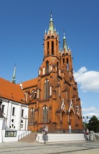 Red brick church with high, pointed towers and a clear sky, Church of the Blessed Virgin Mary,