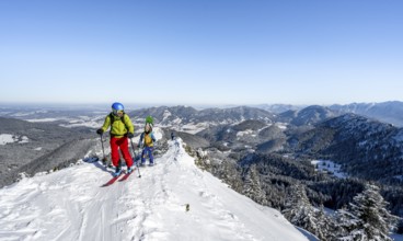 Two ski tourers on a mountain ridge, on the ascent to the Teufelsstättkopf, snowy mountain