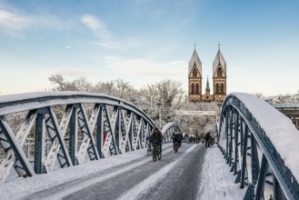 Bridge with snow and ice and cyclists, Blue Bridge and Stühlinger Church, Freiburg im Breisgau,