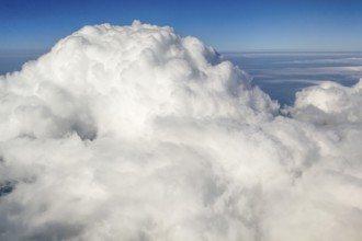 View from at 11887 metres 39000 feet altitude on top dome of large giant white cumulonimbus cloud,