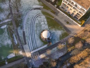 Aerial view of a park with wooden ball in the centre, surrounded by buildings and snow-covered