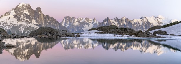 Evening mood with pink evening sky, mountain landscape at sunset, water reflection in Lac Blanc,