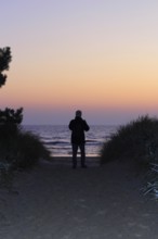 Sunrise on the Baltic Sea beach near Karlshagen, man with camera, September, Usedom,