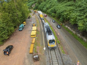 Aerial view of a construction site on a railway line with traffic and construction vehicles,