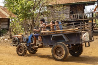 Children on a two-wheel tractor in the village of Ban Baktheung in the Bolaven Plateau, Laos, Asia