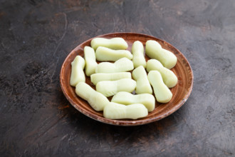 Jelly celery candies on black concrete background, side view, close up