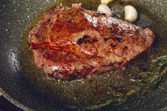 Fried steak, beef steak, rib eye steak, in a frying pan, top view, no people