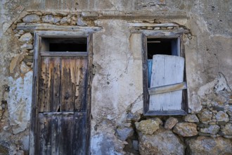 Old, weathered house façade with wooden door and shutters in rustic style, Mesochori village, west