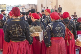 Traditionally dressed Greek women carrying gifts during marriage celebration, Chania, Crete, Greek