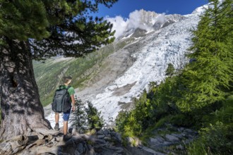 Mountaineer in front of impressive mountain landscape with glacier, view of Glacier des Bossons and