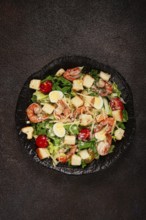 Caesar salad with tiger prawns, shrimp salad, lettuce leaves, quail eggs, cherry tomatoes, parmesan