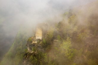 The bright Wartturm above the Elbe river, hidden in dense fog. Seen from the Bastei rocks near the