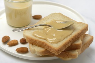 Almond cream on toast, almonds and spoon