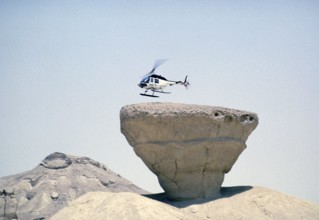 Bell 206 JetRanger helicopter landing on a rocky outcrop Arabian Desert, Saudi Arabia Oil industry