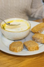 Creamy soup in a bowl with several slices of bread on a plate, autumn creations, Cafe Kuh,