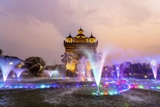 Colourfully illuminated fountain at Patuxai Victory Gate at dusk, capital Vientiane, Laos, Asia