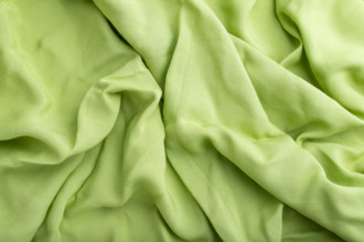 Fragment of green linen tissue. Top view, natural textile background and texture. wave concept,